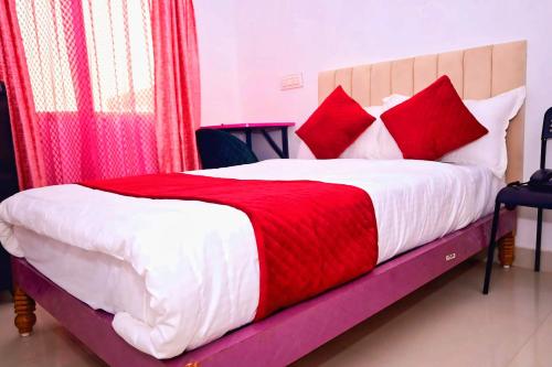 Un dormitorio con una cama con almohadas rojas y blancas. en Pandooi Prasth, Patna, en Patna