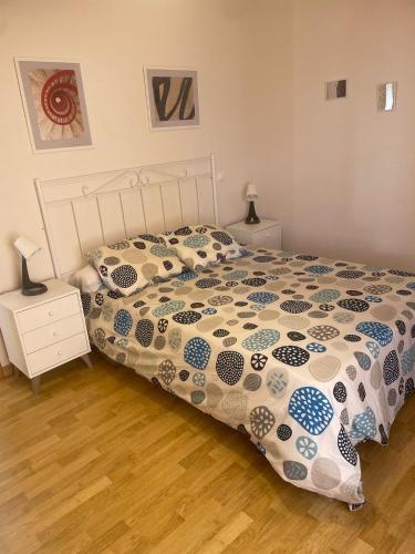 a bedroom with a bed with a comforter on it at Cuencaloft Villa Paraíso in Carrascosa del Campo