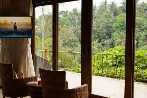 Habitación con vistas a un balcón con sillas. en The Allure Ubud Villas & Spa crafted by freshWater Asia, en Ubud