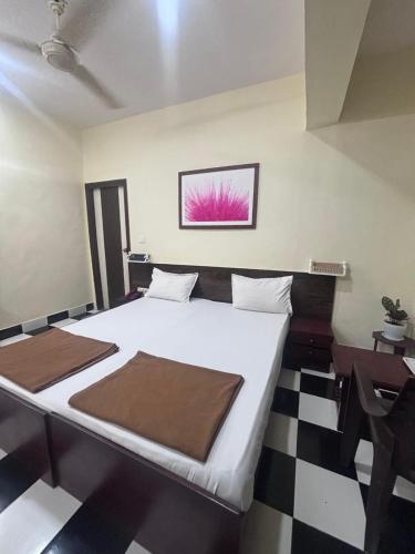 a bedroom with a bed and a black and white checkered floor at Hotel Sainath in Jāmb