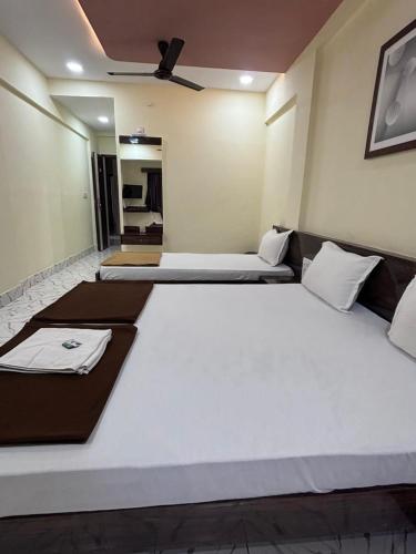 a large bed in a room with two beds at Hotel Sainath in Jāmb