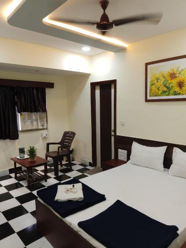 a bedroom with a bed and a black and white checkered floor at Hotel Sainath in Jāmb
