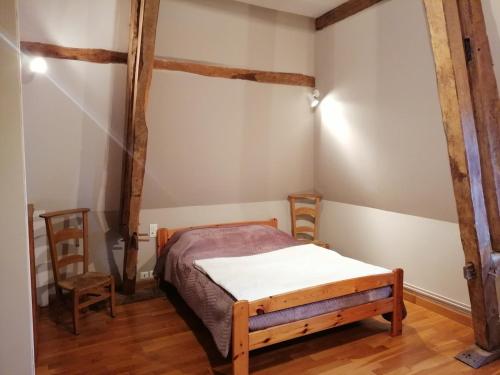 a small bedroom with a bed and two chairs at Le Château d'Ognies in Dohis