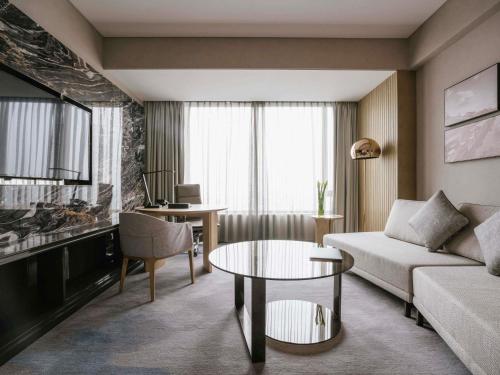 a living room with a couch and a table at Pullman Shanghai Qingpu Excellence in Shanghai