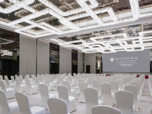 a large room with white chairs and a projection screen at Pullman Shanghai Qingpu Excellence in Shanghai