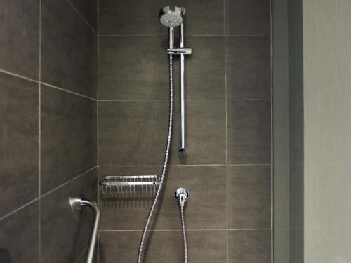 a shower in a bathroom with a shower head at Pullman Vina del Mar San Martin in Viña del Mar
