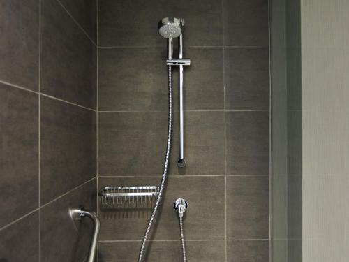 a shower in a bathroom with a shower head at Pullman Vina del Mar San Martin in Viña del Mar