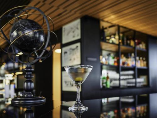 a martini glass sitting on top of a bar at Pullman Vina del Mar San Martin in Viña del Mar