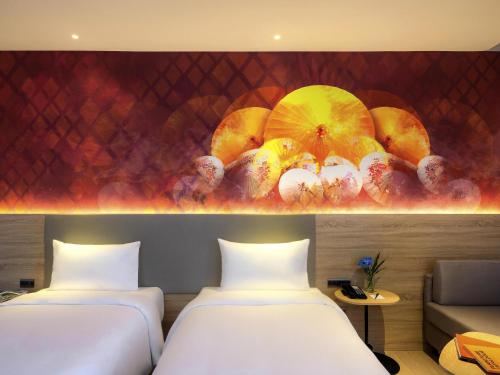 two beds in a room with umbrellas on the wall at ibis Styles Bangkok Ratchada in Bangkok