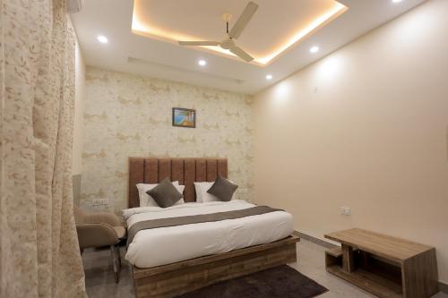 a bedroom with a bed and a couch and a table at Hotel Mango Tree, Vrindavan in Vrindāvan