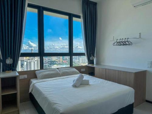 a bedroom with a bed with a large window at Cozy Urban Suites Georgetown View in Jelutong