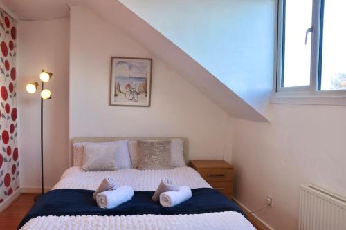 ein Schlafzimmer mit einem Bett mit zwei Kissen darauf in der Unterkunft Comfortable 2 Bed Property with garden - Parking in Hunslet