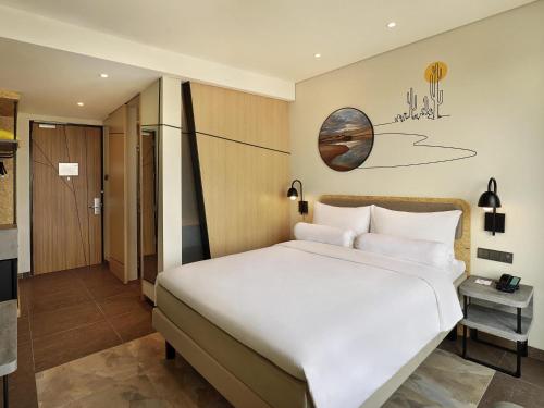 a bedroom with a large white bed in a room at ibis Styles Jakarta Simatupang in Jakarta
