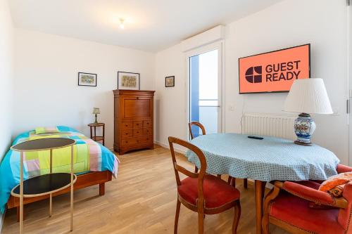 a bedroom with a table and a bed and a table and chairs at GuestReady- Chatillon's Hidden Gems in Châtillon