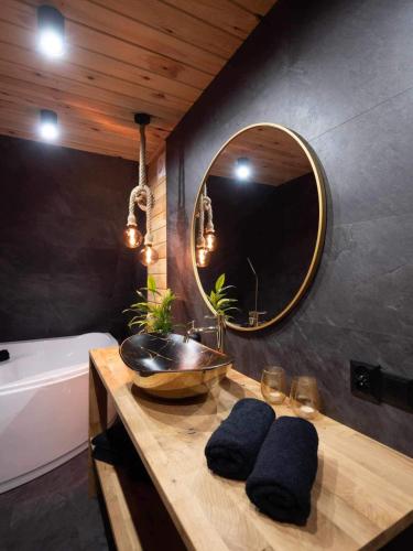 a bathroom with a sink and a tub and a mirror at Chill House in Wierzchucinek