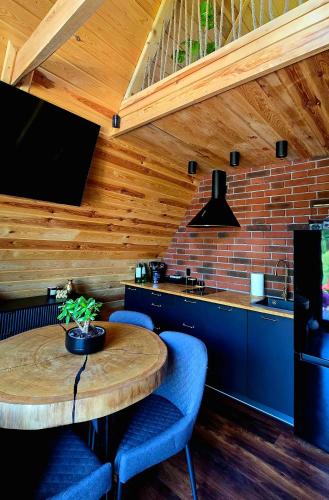a kitchen with a wooden ceiling with a table and blue chairs at Chill House in Wierzchucinek