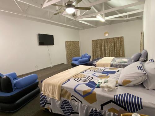 a room with two beds and two blue chairs at Fiet Star in Midrand