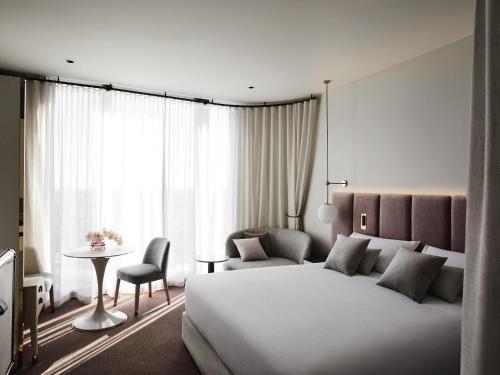 a bedroom with a bed and a table and a chair at Hotel Chadstone Melbourne MGallery Collection in Chadstone