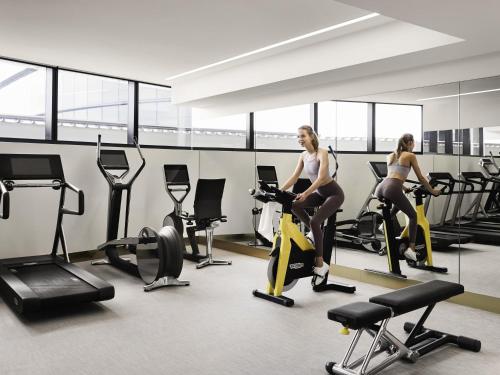 two women riding on exercise bikes in a gym at Hotel Chadstone Melbourne MGallery Collection in Chadstone
