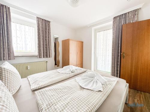 two beds in a room with two windows at Auszeit im Haus Elbe Whg.6 in mitten von Döse, 800m bis zum Strand in Cuxhaven