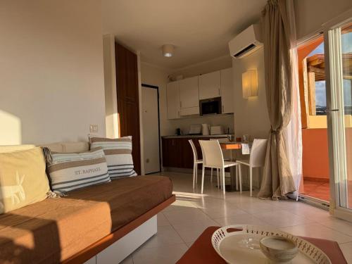 a living room with a couch and a dining room at Splendida vista mozzafiato Costa Rossa Sardegna in Isola Rossa