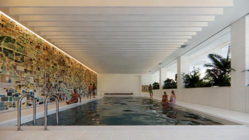 a swimming pool in a building with people in it at Arche Metalowiec Muszyna 