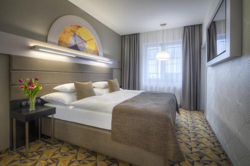 a hotel room with a large bed and a window at Hotel Essence in Prague