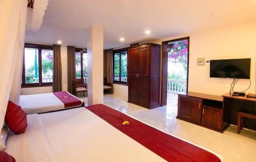 a bedroom with a bed and a flat screen tv at Rock Water Bay Beach Resort & Spa in Xóm Tram
