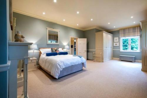 a large bedroom with a bed and a window at Hacheston Lodge in Marlesford