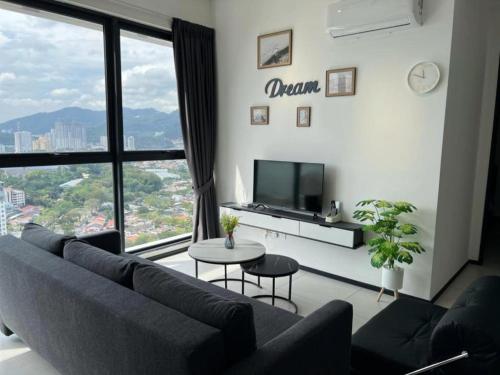 a living room with a couch and a large window at Cozy Urban Suites Georgetown View in Jelutong