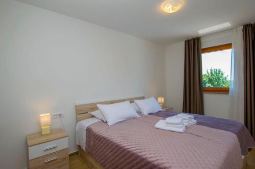 a bedroom with a bed with two towels on it at Villa Nola in Viskovo