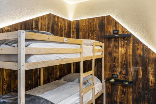 two bunk beds in a room with wooden walls at Ride Home 2 in Commezzadura