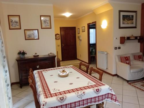 uma sala de jantar com mesa e sofá em B&B Au Petit Bonheur em Saint Vincent