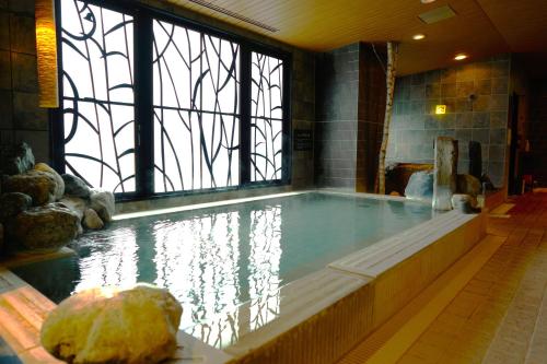 a large pool of water with a large window at Dormy Inn Higashi Muroran in Muroran