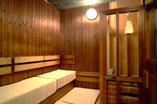 a sauna with two beds in a wooden wall at Dormy Inn Higashi Muroran in Muroran