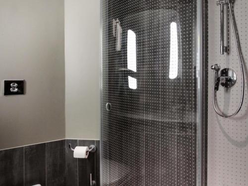 a bathroom with a shower with a glass door at ibis Cahors in Cahors