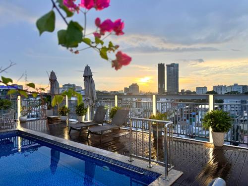 een balkon met een zwembad en uitzicht op de stad bij Cityhouse - LightHouse SG in Ho Chi Minh-stad