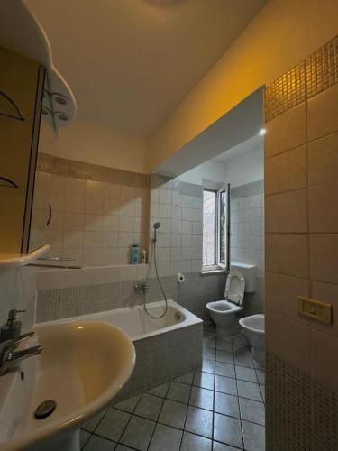 a bathroom with a tub and a toilet and a sink at Double Spaces Apartaments in Tortona