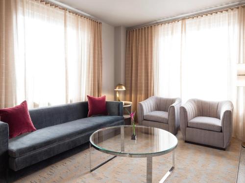 a living room with a couch and a glass table at 21c Museum Hotel Durham in Durham