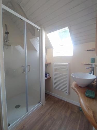Un baño con ducha de cristal y lavabo. en Gîte Youna - Nature et charme breton entre Lizio et Josselin, en Lizio