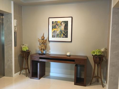 a desk in a hallway with two potted plants at Baan Tanwa - MRT Ratchadapisek in Bangkok