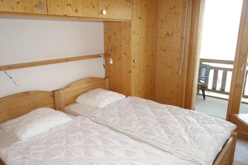 a bed in a room with a wooden wall at Plein Ciel VA 021 MOUNTAIN apartment 8 pers in Veysonnaz