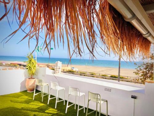 Zimmer mit Stühlen und Strandblick in der Unterkunft Casa Bali in Benajarafe