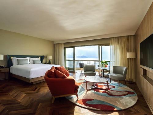 a hotel room with a bed and a large window at Fairmont Rio de Janeiro Copacabana in Rio de Janeiro