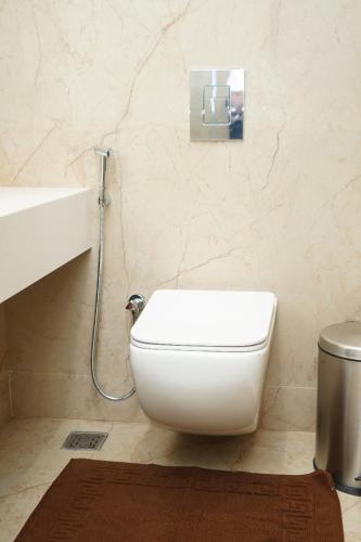 a bathroom with a white toilet and a sink at VANTARA SUITEs in Vellore
