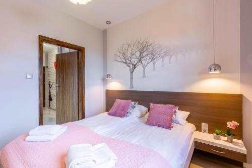 a bedroom with a large bed with pink and white sheets at Blue Sky - Apartamenty w centrum, blisko deptaka, restauracji i atrakcji Karpacza - Obrońców Pokoju 1D in Karpacz