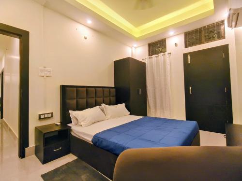 a bedroom with a large bed with a blue blanket at Lir-etso Homestay in Diphu
