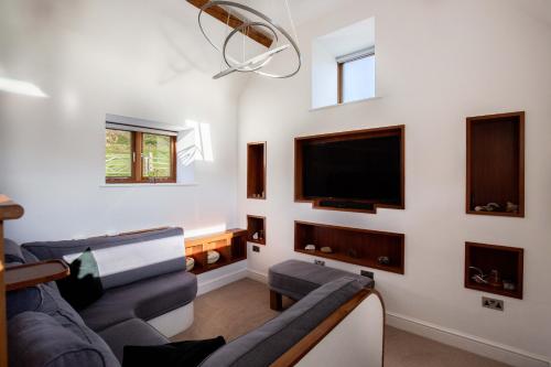 a living room with two couches and a flat screen tv at The Agora in Mollington