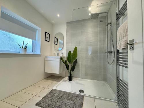 baño blanco con ducha y maceta en Kendal By The Coast - Cosy home in great location, en Blackpool