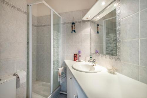 une salle de bain blanche avec lavabo et douche dans l'établissement Pretty Flat in the Sun, à Mandelieu-la-Napoule